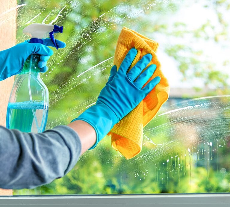 Frau putzt Fenster | © Getty Images/AlexRaths