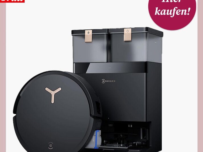 Schwarzer Saug- und Wischroboter mit runder Form und goldfarbenem Logo vor einer passenden Reinigungsstation mit zwei Behältern. | © Ecovacs