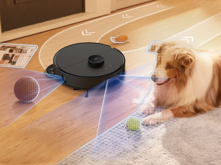 Ein moderner Saugroboter erkennt Hindernisse wie einen liegenden Hund, einen Tennisball und eine Zeitschrift auf Holzfußboden. | © TP-Link