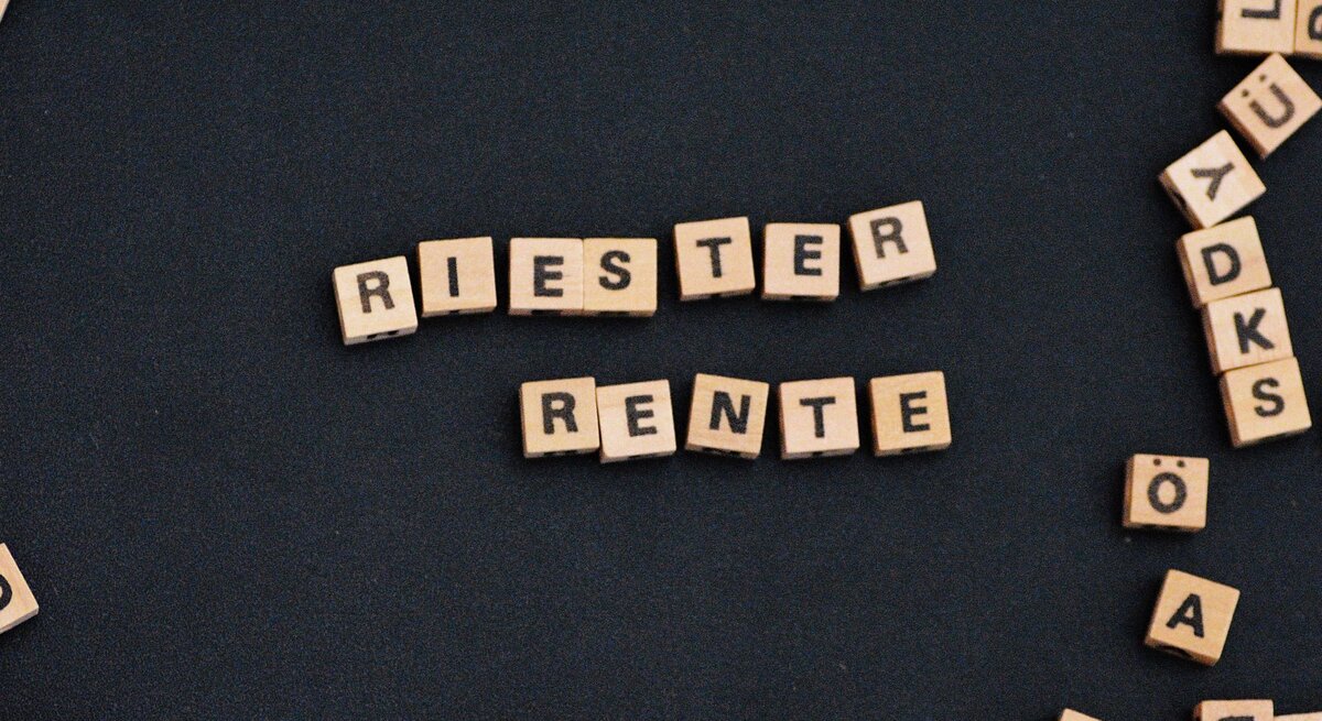 Zu sehen sind Scrabble Lettern, die die Wörter Riester Rente ergeben