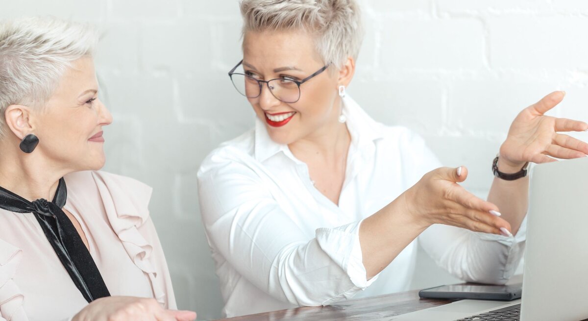 Zu sehen sind zwei sich unterhaltenden Businessfrauen