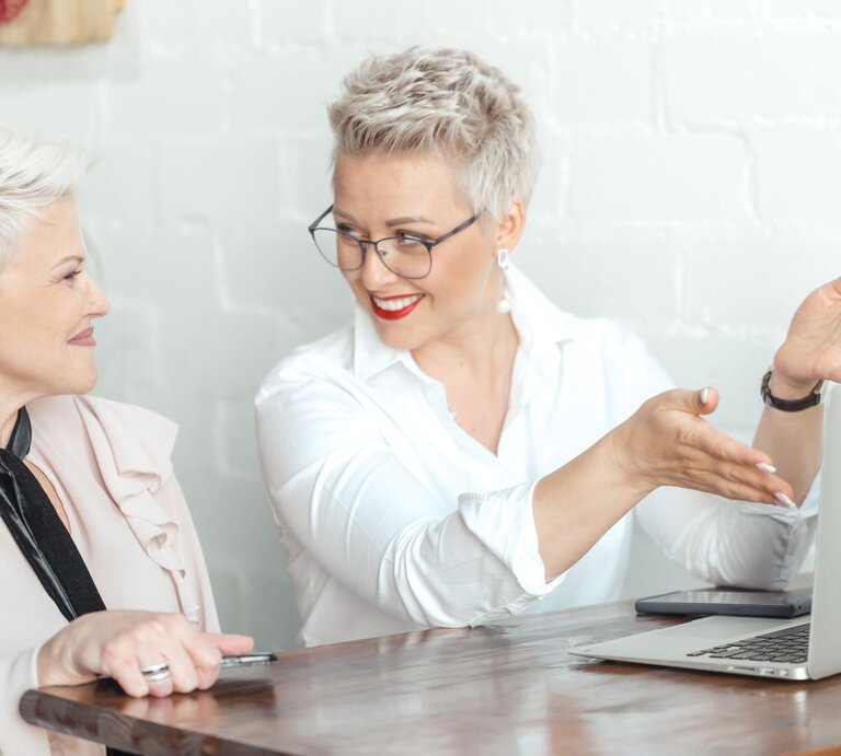 Zu sehen sind zwei sich unterhaltenden Businessfrauen | © Shutterstock/Shakirov Albert