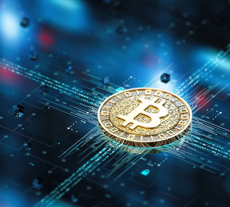 Zu sehen ist ein Bitcoin auf einem festplattenartigen Untergrund. | © GettyImages/BlackJack3D