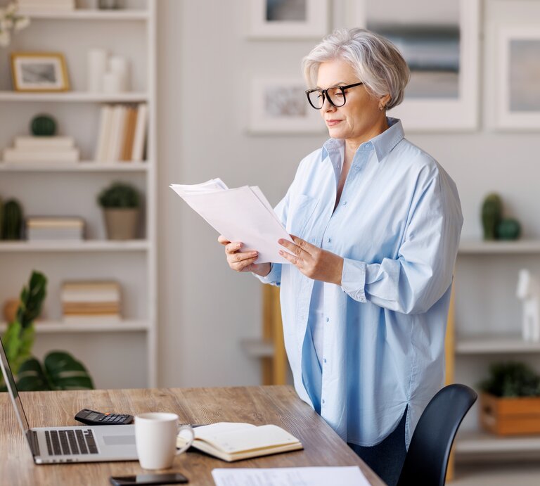 Frau prüft etwas konzentriert an ihrem Schreibtisch | © Shutterstock/Evgeny Atamanenko