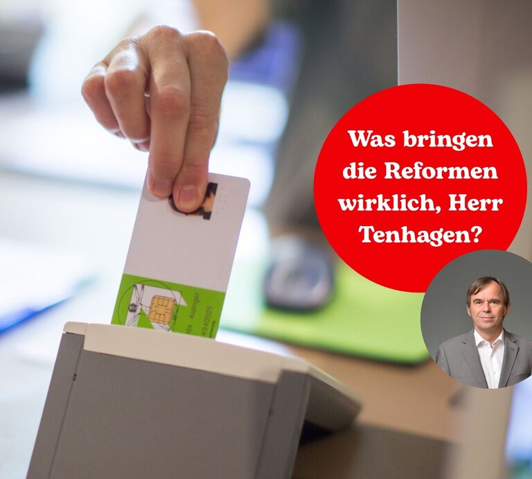 Person steckt eine Krankenkarte in ein Lesegerät beim Arzt.  | © Getty Images