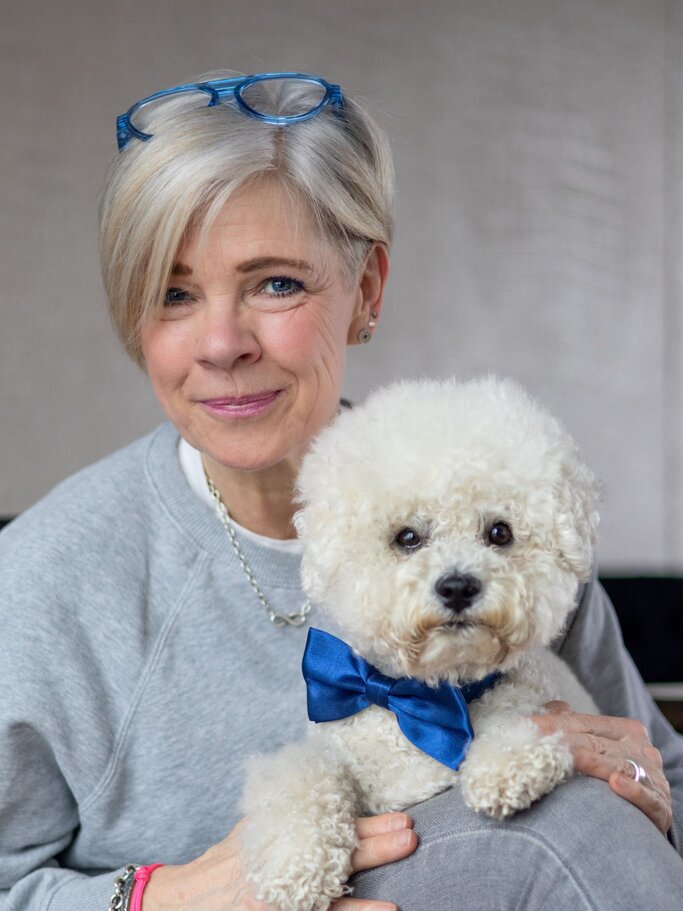 Tierkommunikatorin Sonja Boie hat ihren Hund auf dem Schoss und lächelt. | © Miriam Haferkorn