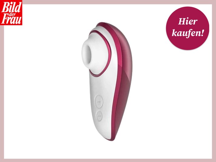 Ein Produktfoto des Auflegevibrators "Womanizer Liberty" in Rosa und Weiß vor einem weißen Hintergrund. In der linken oberen Ecke ist das Logo der "Bild der Frau" und in der rechten oberen Ecke ein runder Button, der den Text "Hier kaufen!" enthält, zu sehen. | © Amorelie