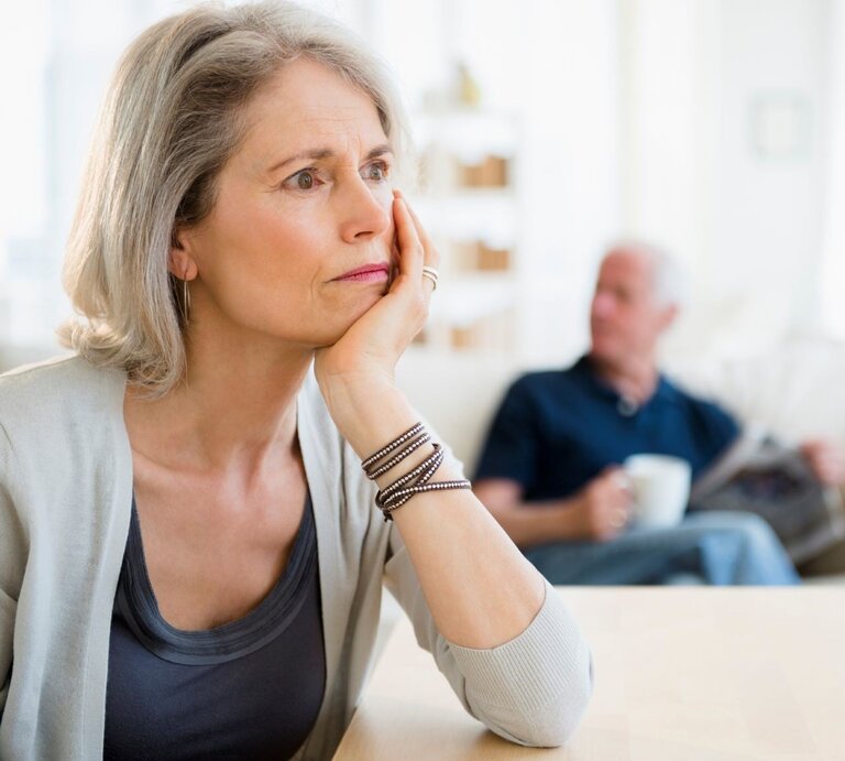 Nachdenkliche Frau und Mann mit Zeitung  | © Getty Images / Deagreez