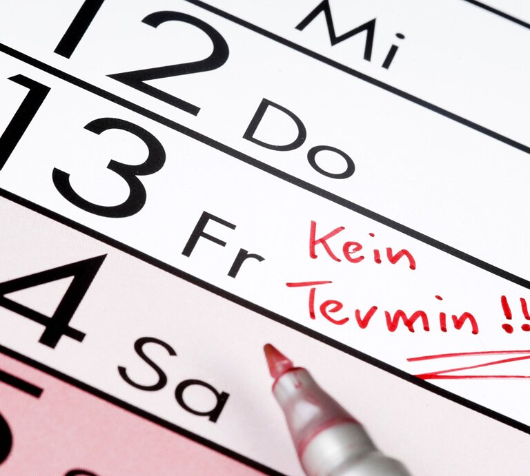 Nahaufnahme eines Kalenders mit dem markierten Datum Freitag, 13., auf dem mit rotem Stift „Kein Termin!!!“ notiert ist. | © Getty Images / Hinterhaus Productions