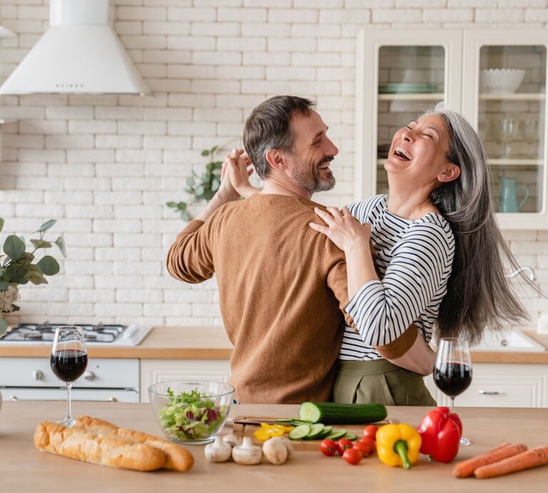 Ein fröhliches Paar tanzt gemeinsam in der Küche. | © Shutterstock/Inside Creative House