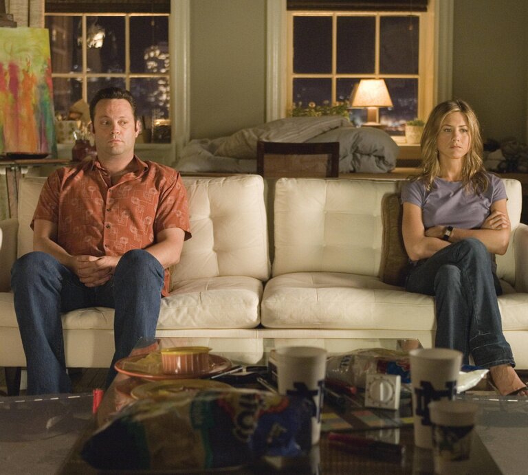 Vince Vaughn und Jennifer Aniston sitzen an gegenüberliegenden Enden eines Sofas. | © Imago