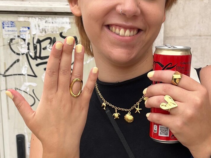 Hände mit gelb lackierten Nägeln tragen Goldschmuck, halten eine Cola-Dose und heben sich vor einem graffiti-verzierten Hintergrund ab. | © BILD der FRAU/ Kaja Wundersitz