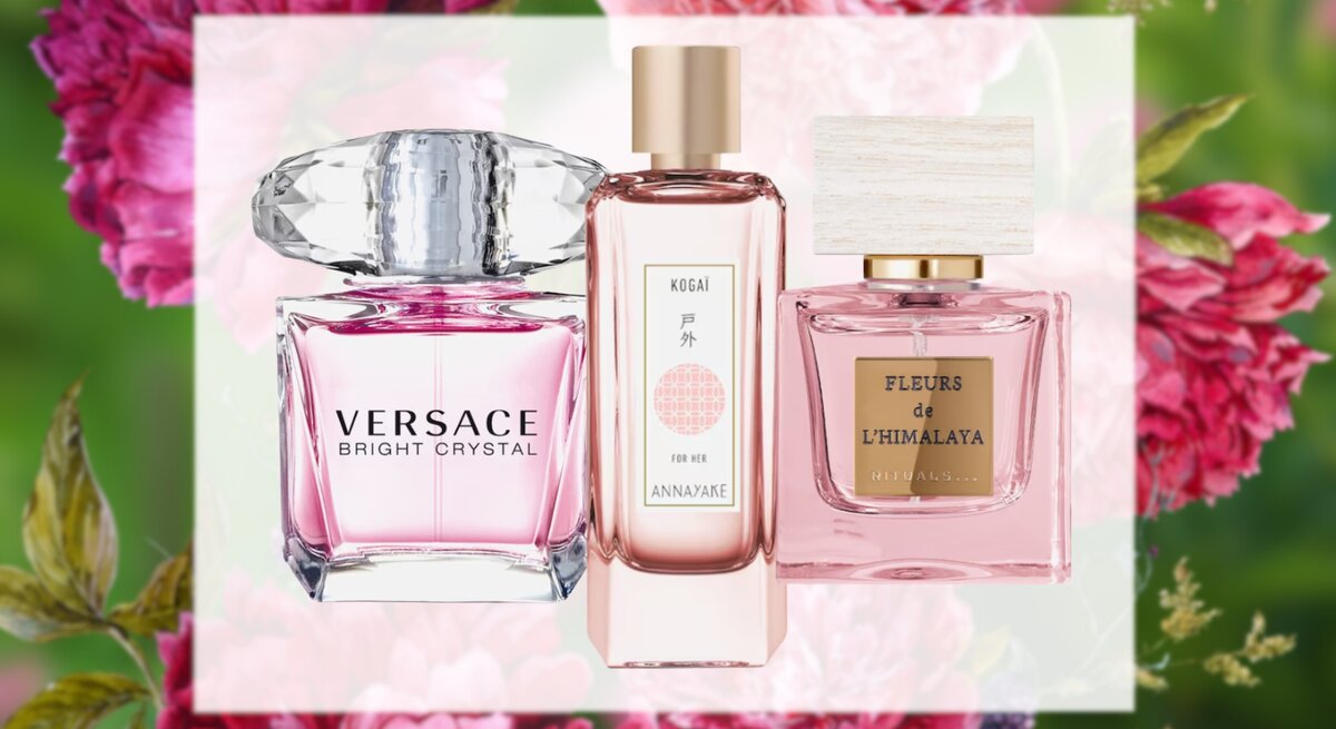 Elegante Parfumflaschen von Versace, Annayake und Rituals leuchten rosa vor einem floralen Hintergrund mit Pfingstrosen.
