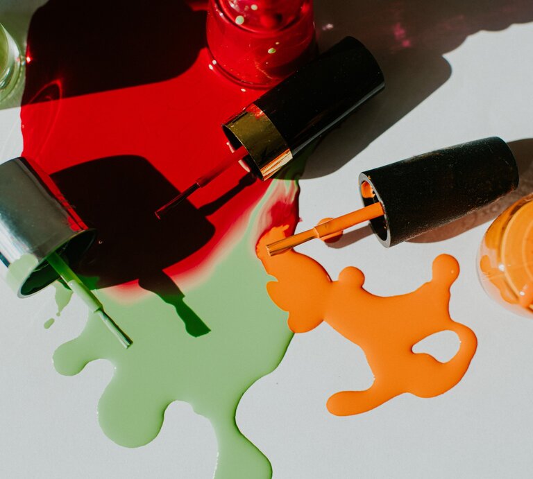 Zu sehen sind verschiedene Nagellackfarben, die teilweise ausgelaufen sind. | © GettyImages/Catherine Falls Commercial