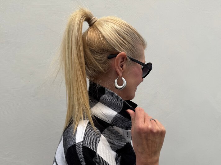 Blondhaarige Renate Zott, mittleren Alters mit hochgebundenem Pferdeschwanz und großen silbernen Creolen im Profil. | © Renate Zott