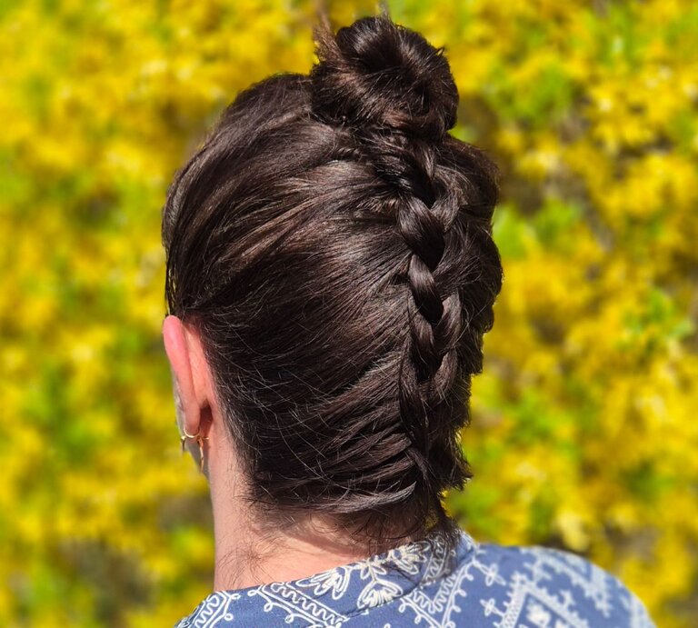 Zu sehen ist eine Frau, die die beschriebene Frisur trägt, mit braunen Haaren, vor einem Osterbusch | © Laura Jordan