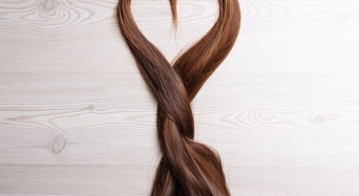 Zu sehen sind braune Haare, die ein Herz formen.