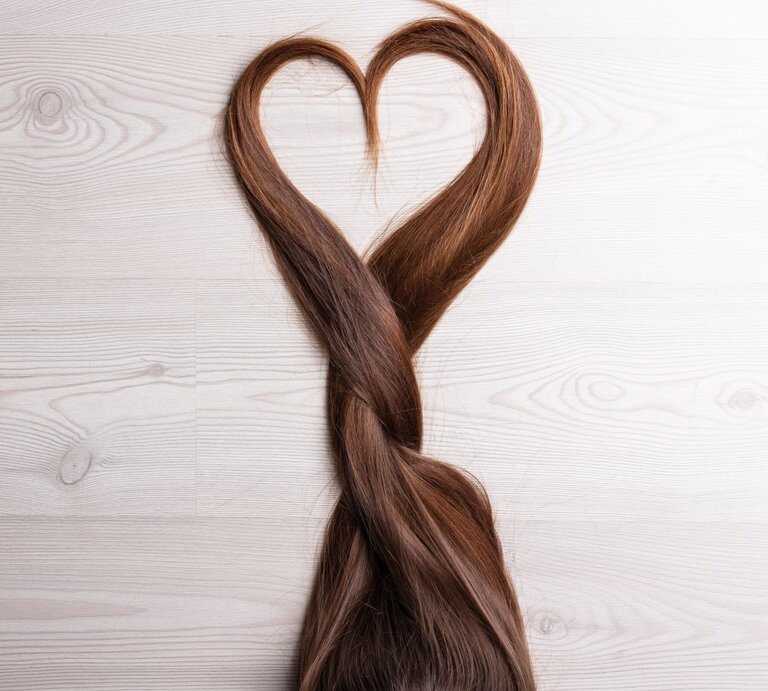 Zu sehen sind braune Haare, die ein Herz formen. | © GettyImgages/Giulio Fornasar