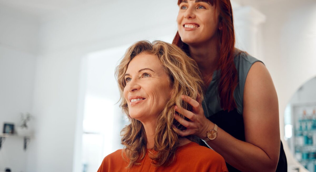 Zu sehen ist eine Frau mittleren Alters, die eine neue Frisur bekommt.