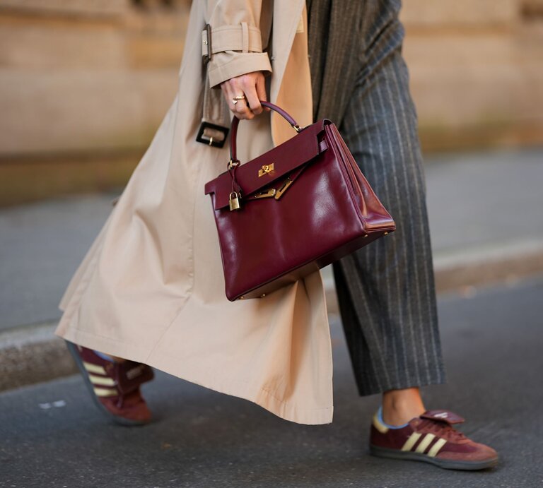 Zu sehen ist ein close-up Shot von Bordeaux farbenen Sneakers | © GettyImages/Moritz Scholz