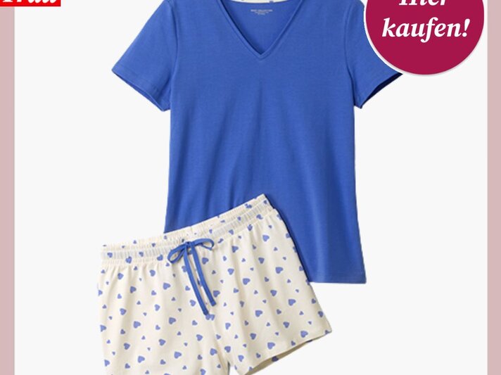 Ein blauer Kurzarm-Pyjama mit V-Ausschnitt und eine weiße Shorts mit blauen Herzmustern, präsentiert auf weißem Hintergrund. | © Tchibo