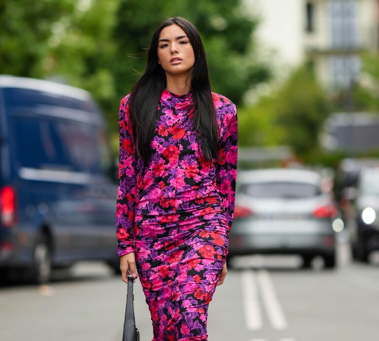 Zu sehen ist eine Frau in einem bunten Kleid | © GettyImages/Edward Berthelot