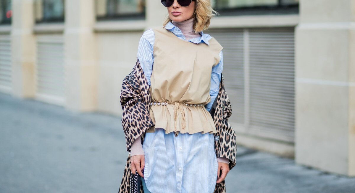 Zu sehen ist eine blonde Frau, die einen stylischen Layeringlook trägt.