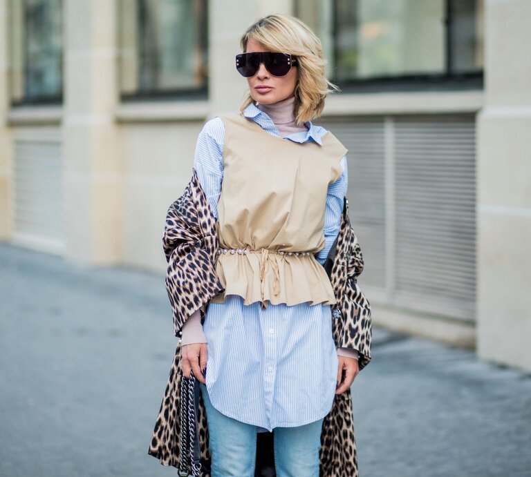 Zu sehen ist eine blonde Frau, die einen stylischen Layeringlook trägt. | © GettyImages/Christian Vierig 