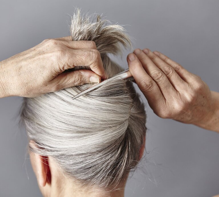 Zu sehen ist eine Frau mit grauen Haaren, die einen French Twist trägt | © GettyImages/Maria Fuchs