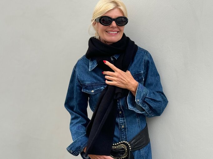 Stilvolle Frau in einem lässigen Herbst-Outfit. Sie trägt eine dunkle Sonnenbrille, einen schwarzen Schal und eine dunkelblaue Jeansjacke. | © Renate Zott