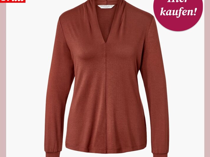Rostrotes Langarmshirt mit elegantem V-Ausschnitt und leicht fallendem Stoff vor weißem Hintergrund präsentiert. | © Tchibo