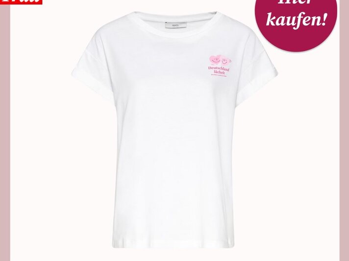 Weißes T-Shirt mit rosa Herzen und dem Schriftzug "Deutschland lächelt" von Bild der Frau, daneben ein Kreis mit "Hier kaufen!". | © Bonita