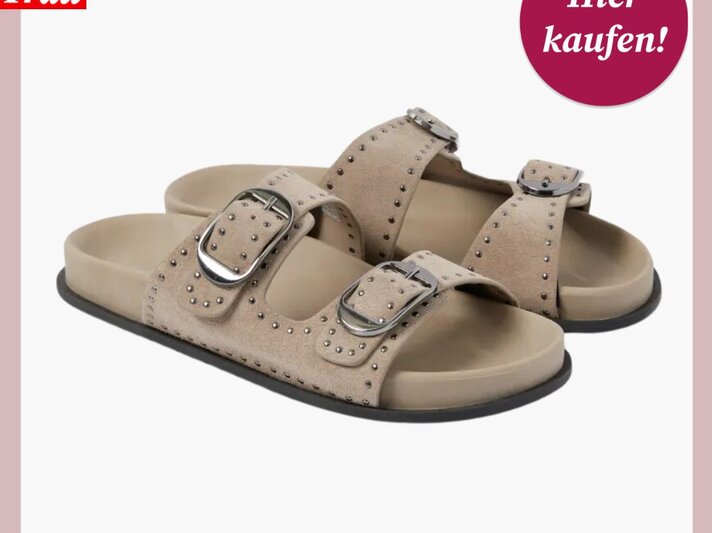 Beigefarbene Sandalen mit zwei breiten Riemen, verziert mit silbernen Nieten und großen Schnallen, auf weißem Hintergrund. | © C&A