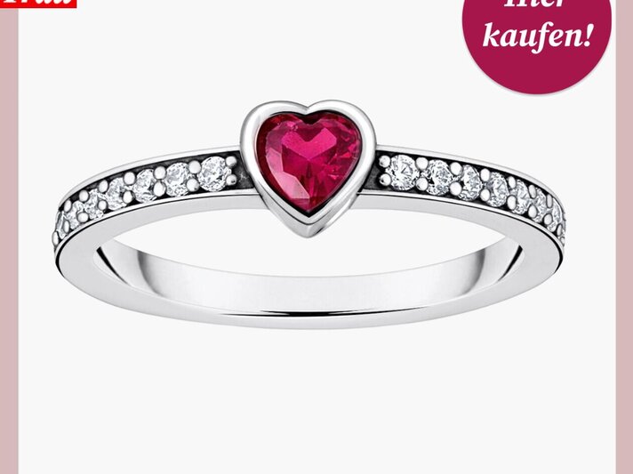 Zierlicher Silberring mit einem roten Herzstein und seitlich eingefassten Diamanten auf weißem Hintergrund. | © Thomas Sabo