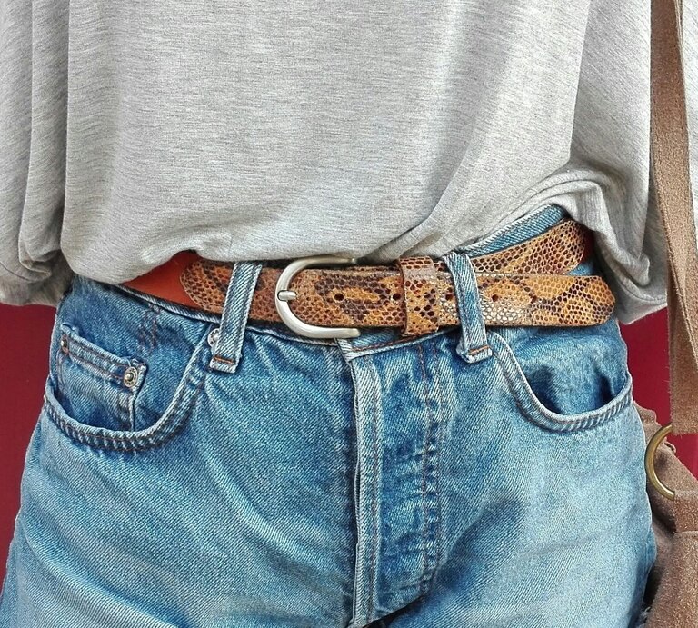 Frau in Jeans: Von ihr sind nur die vorderen Taschen der Hose, der Gürtel und ein Stück vom Oberteil zu sehen, das in die Jeans gestopft ist. | © Getty Images / Vitria Silva / EyeEm