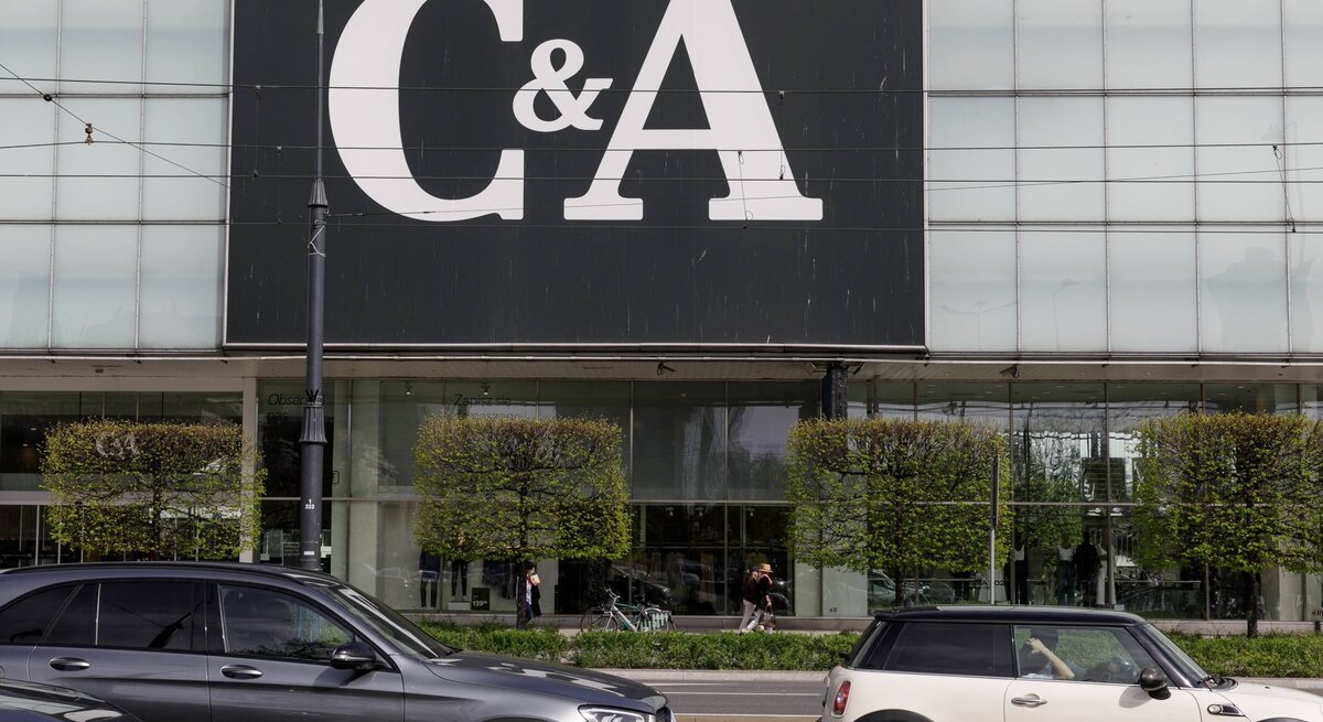 C&A-Gebäude mit großem Logo, davor fahren Autos auf der Straße