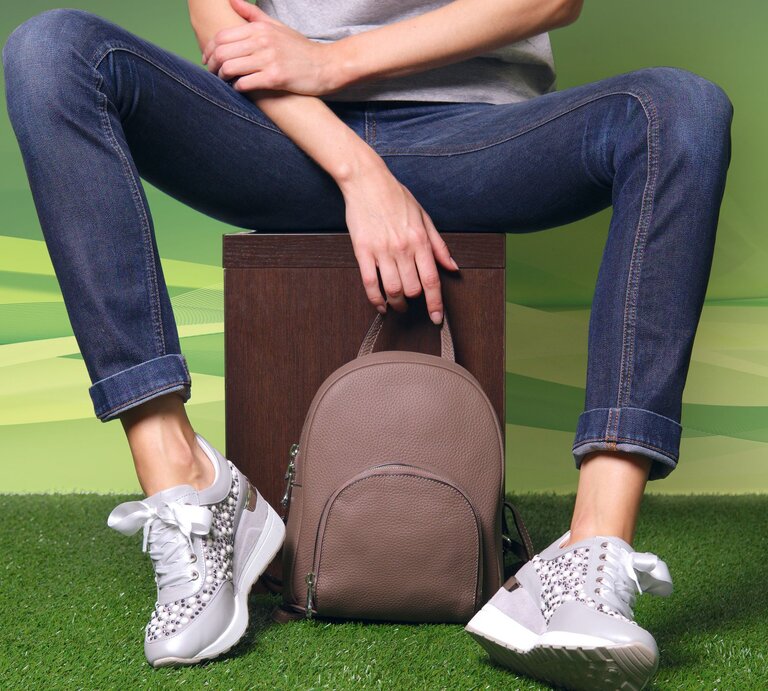 True blue Jeans an den Beinen, sitzend auf einem Hocker. Weiße Sneaker an den Füßen, verschränkte Arme. | © IMAGO / Panthermedia