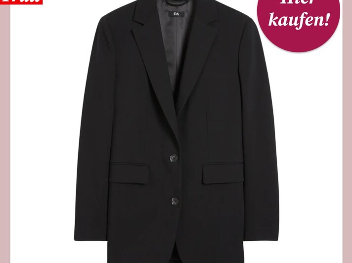 Das Bild zeigt einen schicken, schwarzen Oversize-Blazer vor einem weißen Hintergrund. Er ist klassisch mit einem Reverskragen, Knopfverschluss und aufgesetzten Taschen gestaltet. In der oberen linken Ecke ist das Logo "Bild der Frau" zu sehen, und oben rechts befindet sich ein magentafarbener Button mit der Aufschrift "Hier kaufen!". Der Blazer scheint aus einem glatten, robusten Stoff gefertigt zu sein und bietet eine vielseitige Ergänzung für jede Garderobe. | © C&A