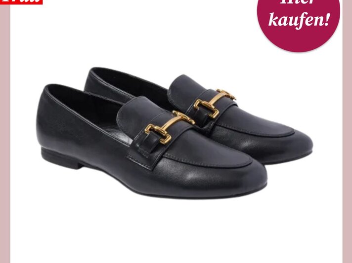 Das Bild zeigt ein Paar klassische schwarze Loafers mit niedrigem Absatz und goldfarbenen Schnallen. Sie sind vor einem weißen Hintergrund mit rosa Umrandung platziert, was die Schuhe hervorhebt. Oben links befindet sich das Logo "Bild der Frau", und oben rechts ist ein magentafarbener Button mit der Aufschrift "Hier kaufen!". Diese Schuhe verkörpern einen zeitlosen und eleganten Stil, der sich sowohl für formelle Anlässe als auch für den Alltag eignet. | © C&A