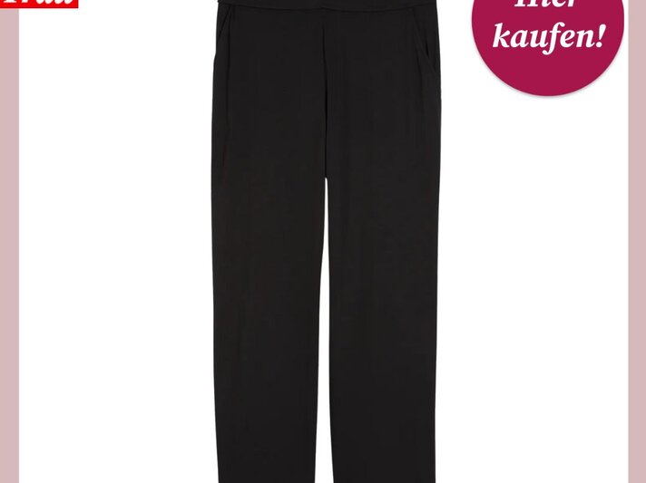 Das Bild zeigt eine schwarze Hose mit geradem Beinschnitt vor einem weißen Hintergrund mit einer rosa Umrandung. Die Hose besitzt einen glatten Bund ohne sichtbare Verschlüsse, was auf einen schlanken und minimalistischen Stil hindeutet. Oben links im Bild ist das Logo "Bild der Frau" zu sehen, und oben rechts befindet sich ein magentafarbener Button mit der Aufschrift "Hier kaufen!". Die präsentierte Hose könnte für eine Vielzahl von Anlässen geeignet sein, von formellen bis hin zu legeren Zusammenkünften. | © C&A