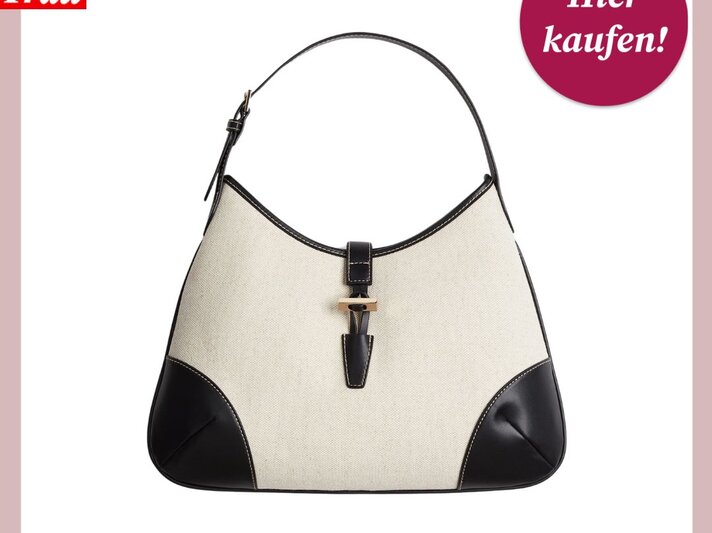 Eine Handtasche mit cremefarbener Textiloberfläche und schwarzem Lederbesatz, versehen mit einem markanten, schwarz-braunen Verschluss, präsentiert mit einem "Hier kaufen!"-Button der 'Bild der Frau'. | © H&M