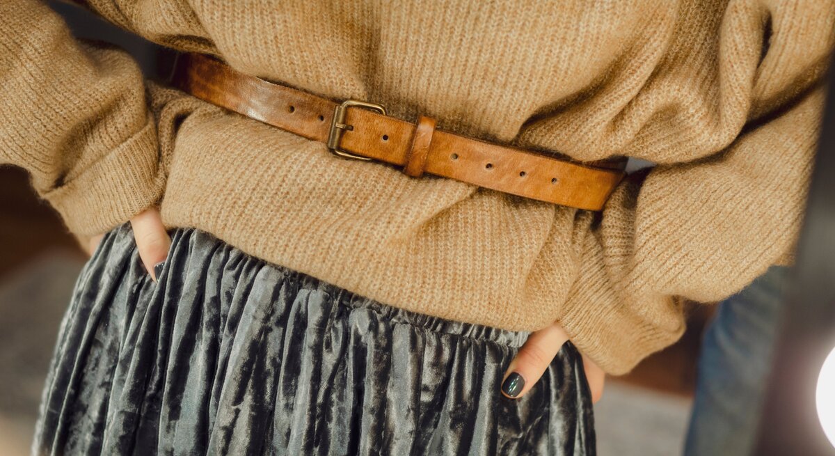 Frau trägt einen braunen Pullover und einen braunen Taillengürtel aus Leder