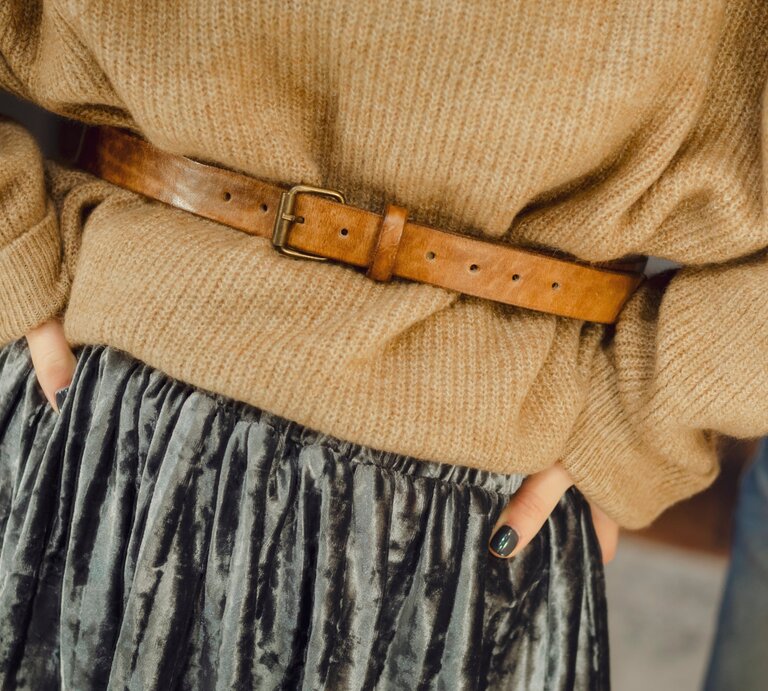 Frau trägt einen braunen Pullover und einen braunen Taillengürtel aus Leder | © Shutterstock/Halinskyi Max