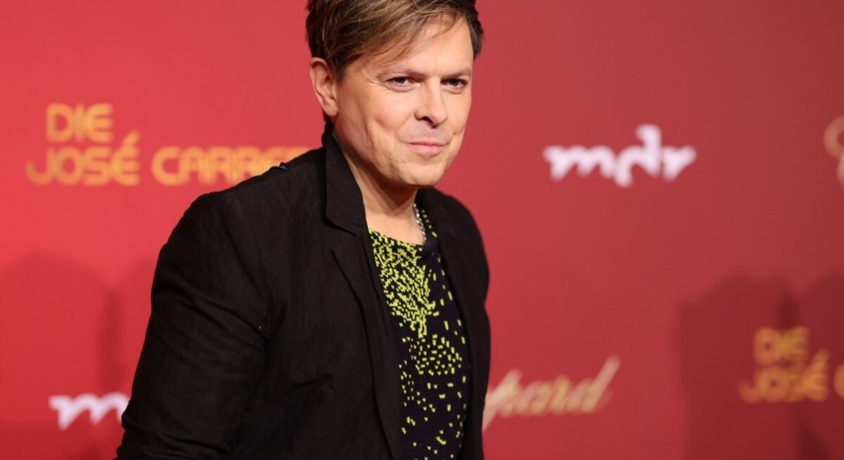 Sänger Michael Patrick Kelly lächelt auf einem Roten Teppich in die Kameras 