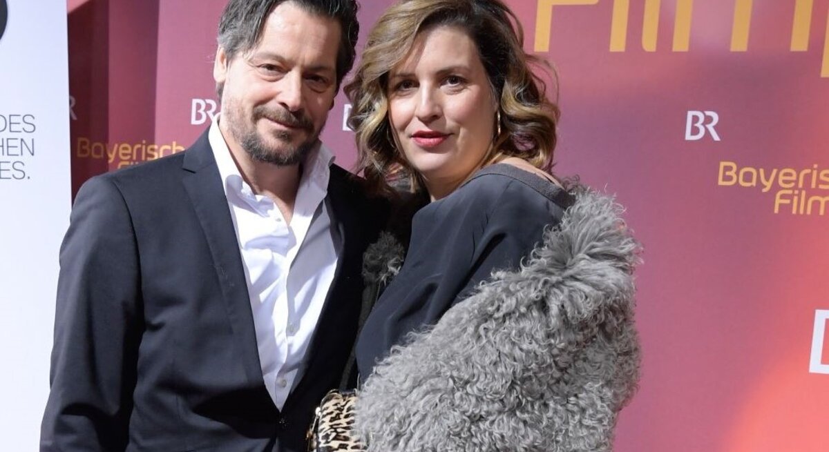 Schauspielerin Elena Uhlig und Schauspieler Fritz Karl stehen bei einer Veranstaltung nebeneinander auf dem roten Teppich