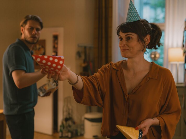 "Feste Feiern": Franzi (Julia Becker) und Karstens (Richard Kreutz) stehen in der Küche. Sie hat einen Partyhut auf dem Kopf und hält einen in der ausgestreckten Hand. | © Marcus Gaertner/ ZDF
