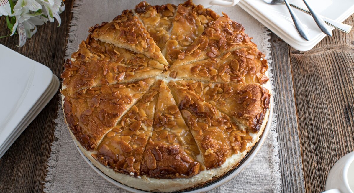 Omas Bienenstich-Torte auf rundem Kuchenteller / Untergrund rustikaler Holzboden / 