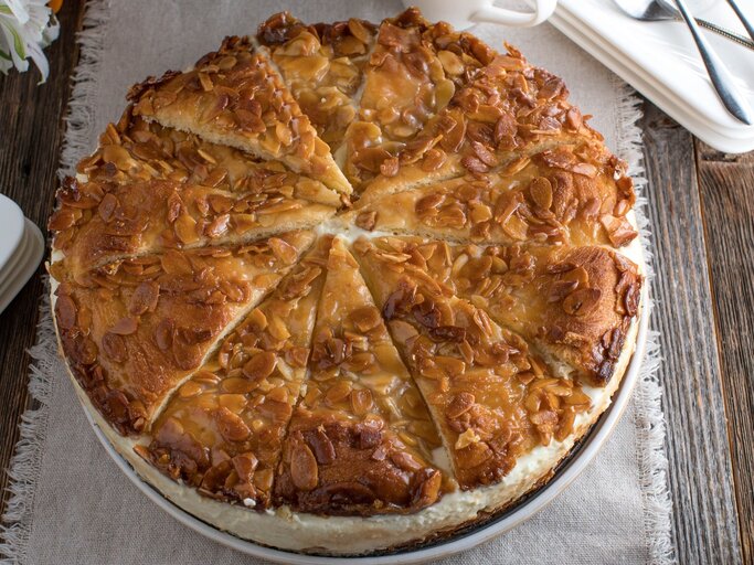 Omas Bienenstich-Torte auf rundem Kuchenteller / Untergrund rustikaler Holzboden /  | © Adobe Stock/Angelika Heine