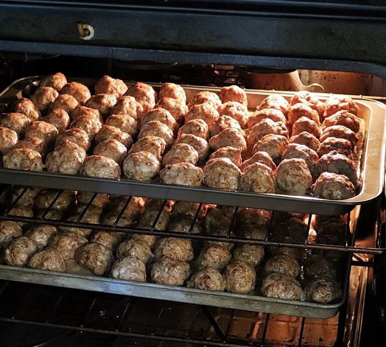 Frikadellen im Backofen zubereiten / zwei Bleche mit Hackbällchen / Draufsicht, schräg | © Adobe Stock / Amelia