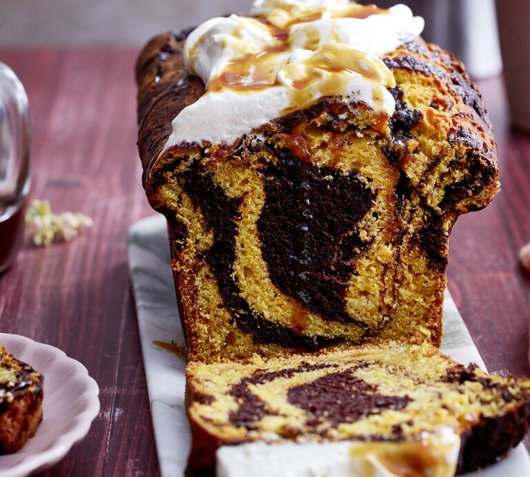 Kürbis-Kakao-Kuchen auf einem grauen Servierteller, auf dunkelrotem Hintergrund.  | © EAT CLUB/Isabell Triemer